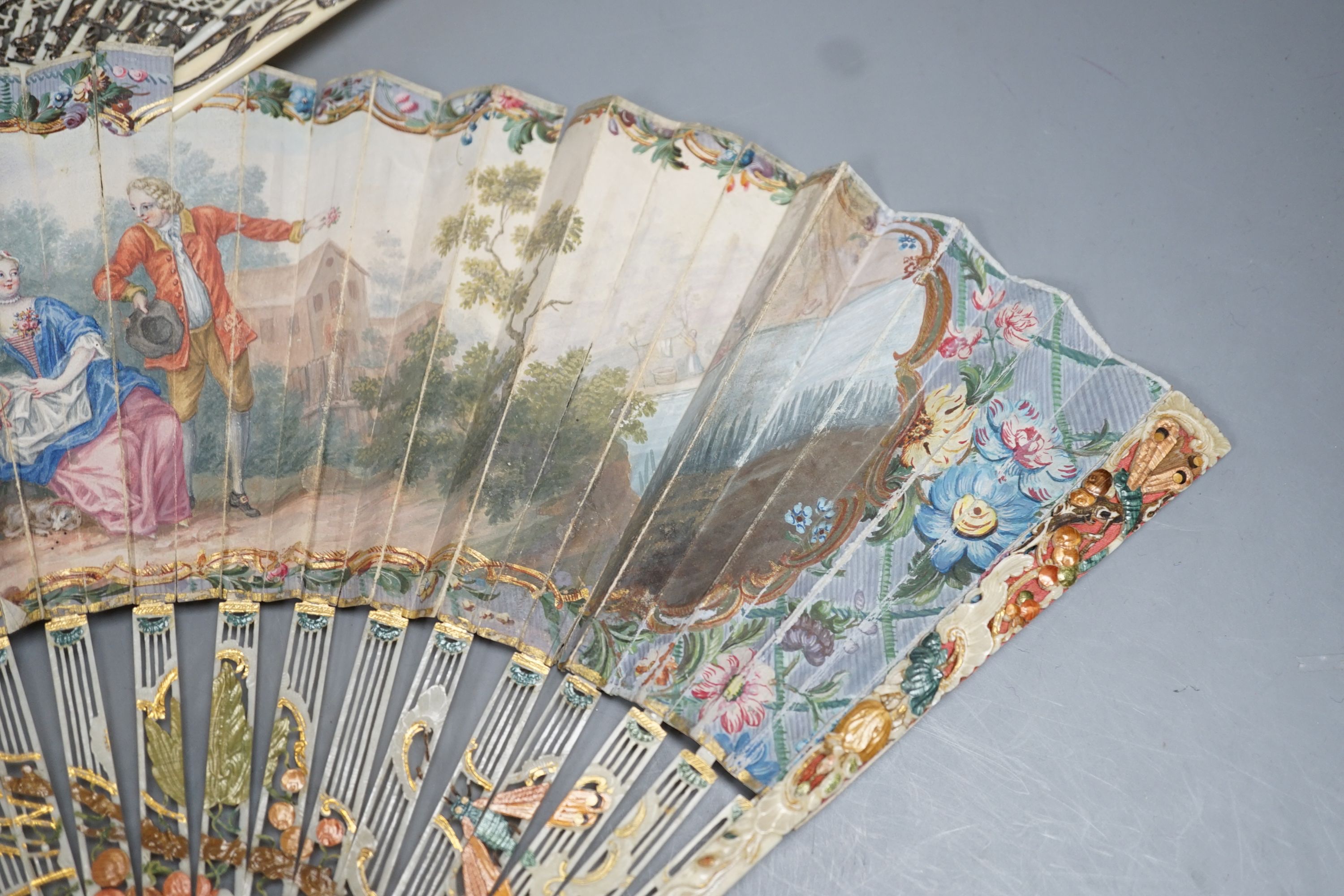 Two late 18th/early 19th century French gilded and silvered ivory and painted paper leaf fans